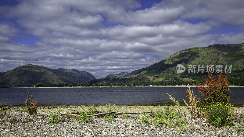 从布里(Bunree)的卵石海滩上看，从林荷湖(Loch Linnhe)上俯瞰阿德古尔半岛的山脉。